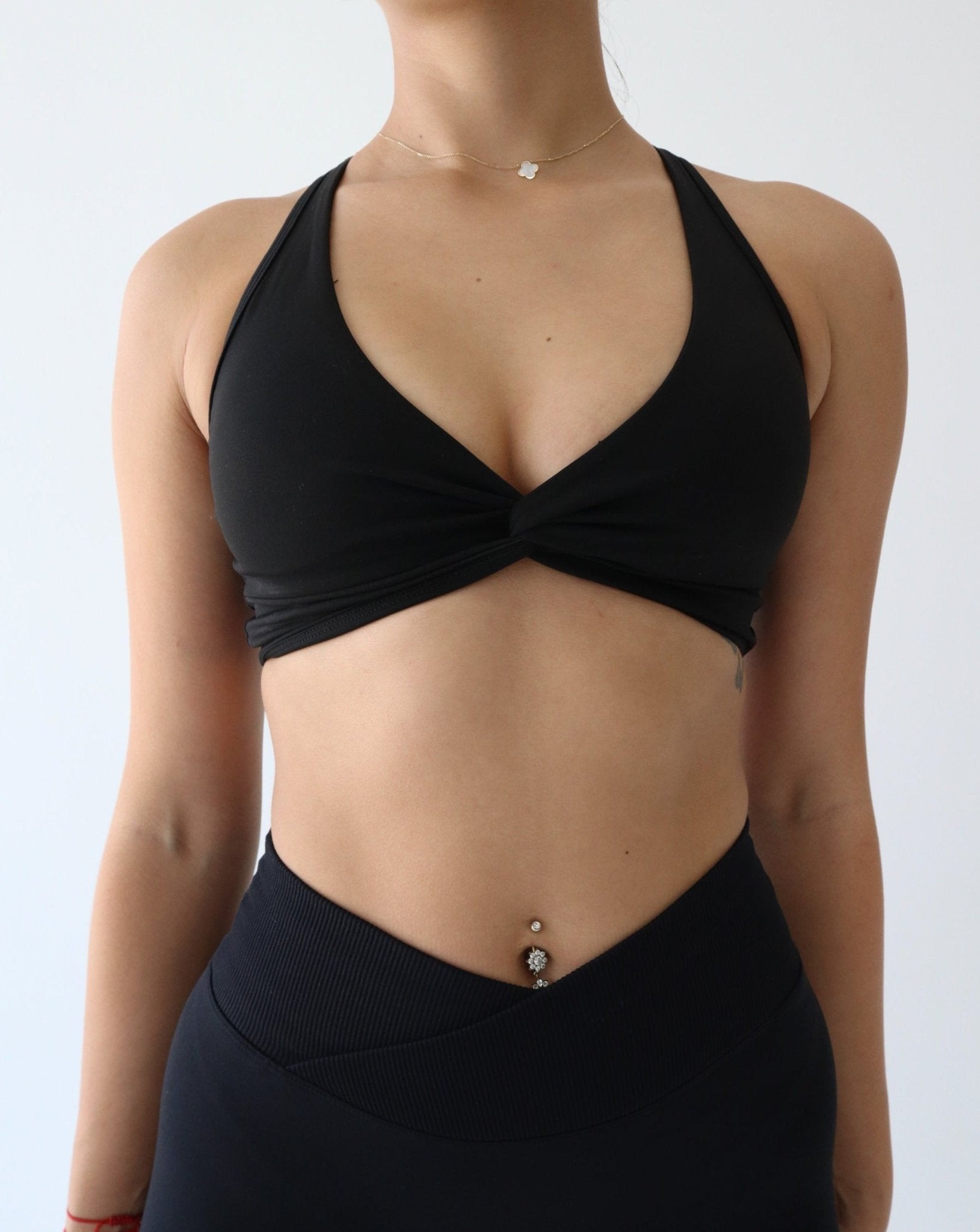Plunge Medium Hold Sports Bra - BLACK - LIBERA Fitness Apparel. Discover the Enhance Medium Hold Sports Bra, designed for maximum support and comfort. Featuring an elegant twist design and adjustable straps, it's perfect for high-impact workouts.