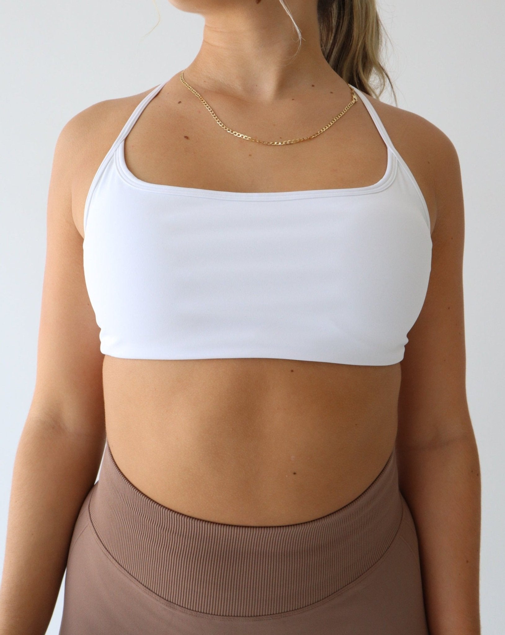 REFINE Sports Bra - WHITE - LIBERA Fitness Apparel. Upgrade your workout attire with our Refine Sports Bra, crafted from double-layered, stretchy fabric for breathability and opacity. Versatile styling options for every gym session.